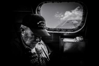grayscale photo of man in plaid shirt and cap looking at the sky by Eric Ward courtesy of Unsplash.