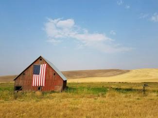 flag of United States of America hanged on brown house during daytime by specphotops courtesy of Unsplash.