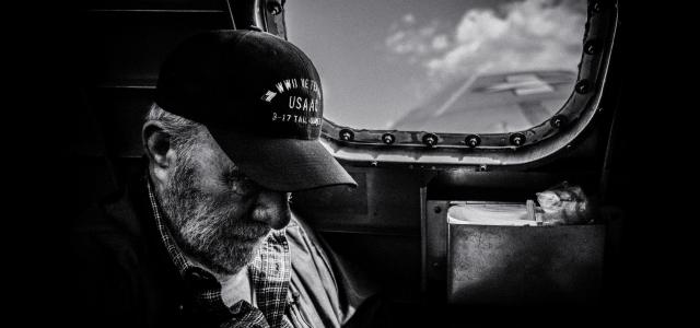 grayscale photo of man in plaid shirt and cap looking at the sky by Eric Ward courtesy of Unsplash.